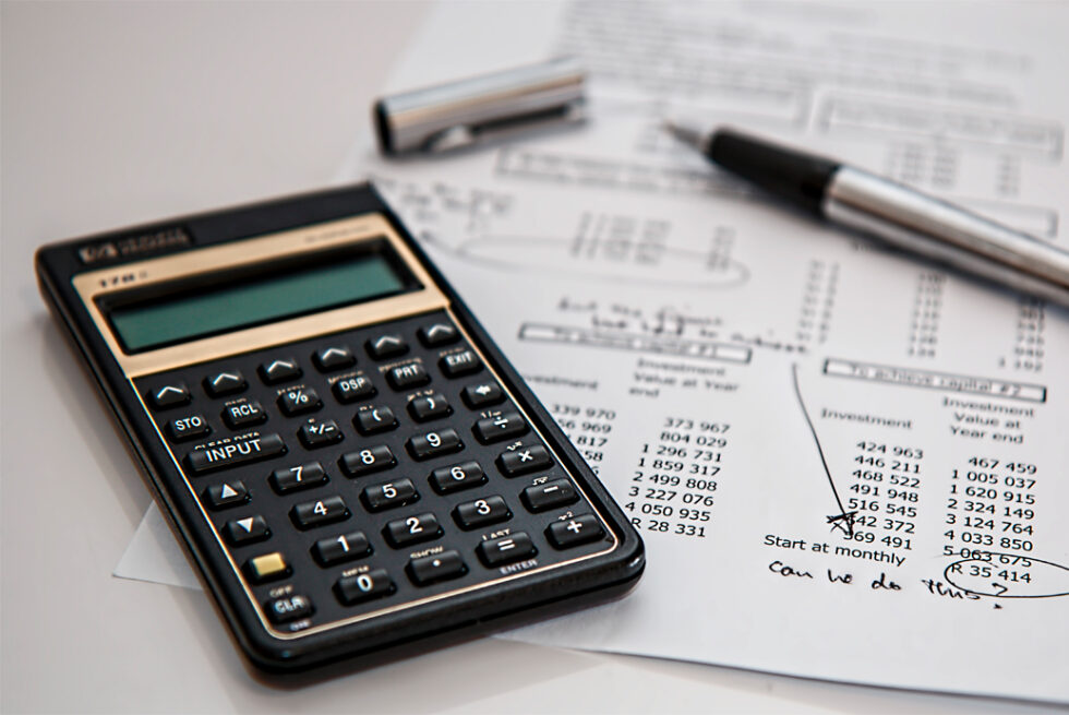 Profesional revisando planillas con calculadora financiera