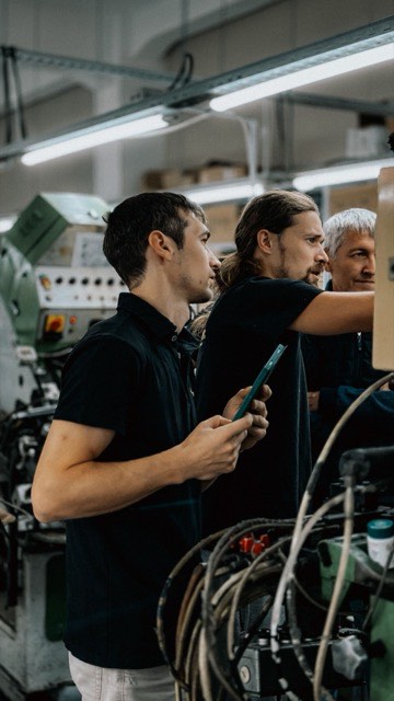 Operarios supervisando maquinaria en una línea de producción industrial