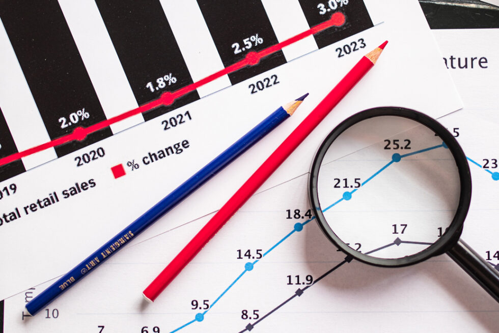 Gráficos de datos impresos analizados con lápices y una lupa